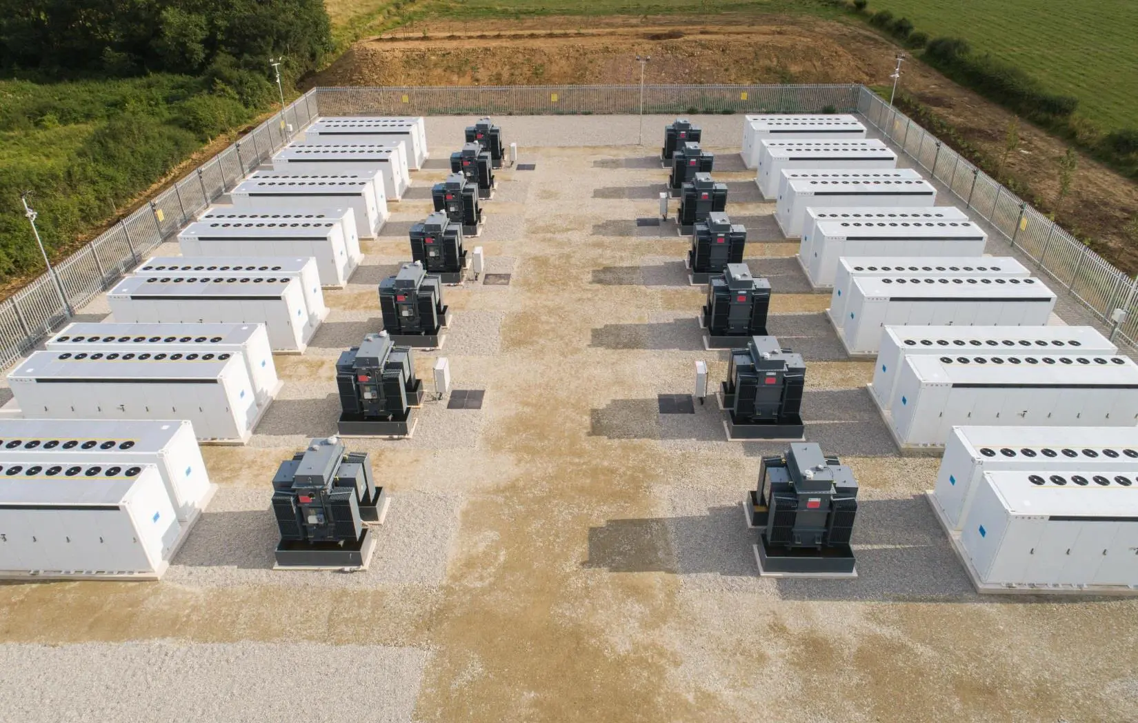 A large group of generators sitting on top of concrete.