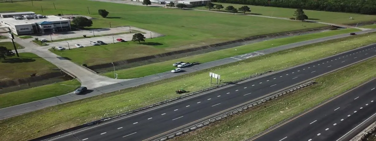 A highway with grass and trees on both sides of the road.